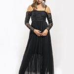 The girl wears a long black dress with long sleeves made of black lace.