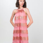 The short-haired brunette wears a short pink DUNJA dress with rhinestone collars.