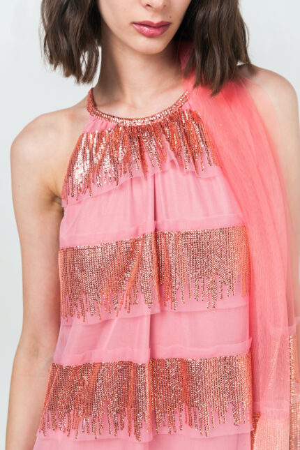 The short-haired brunette wears a short pink DUNJA dress with rhinestone collars.