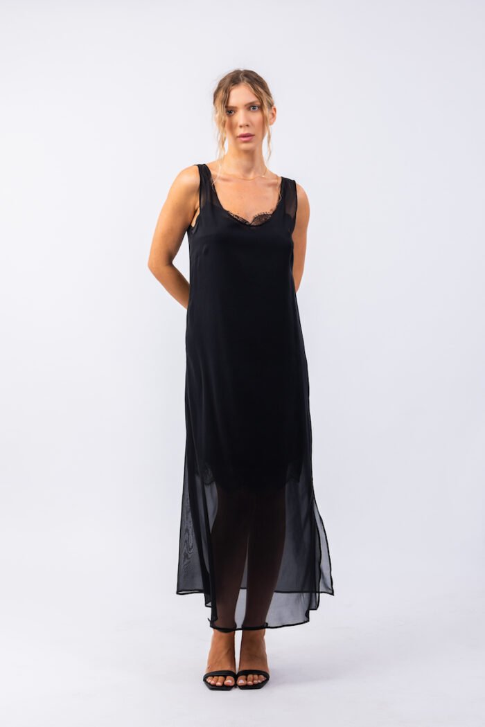 The girl wears a long black sleeveless dress with a cutout.