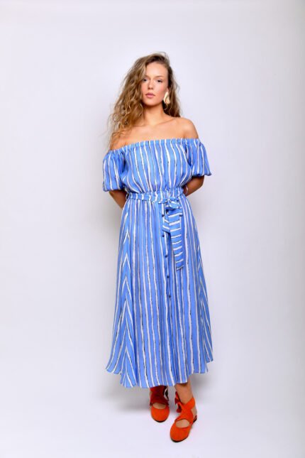 The blonde girl wears a midi blue striped dress made of blue and white silk material.