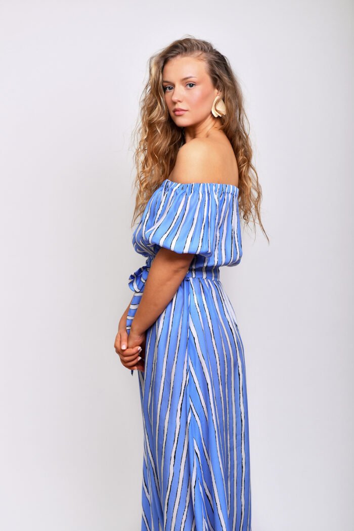 The blonde girl wears a midi blue striped dress made of blue and white silk fabric..