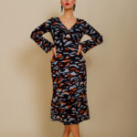 The girl wears a midi EVA dress made of black patterned silk in animal print.