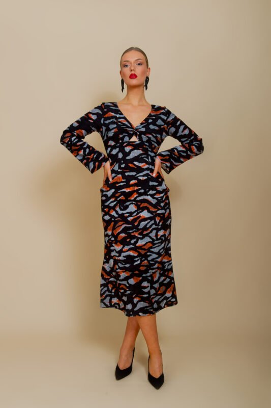 The girl wears a midi EVA dress made of black patterned silk in animal print.