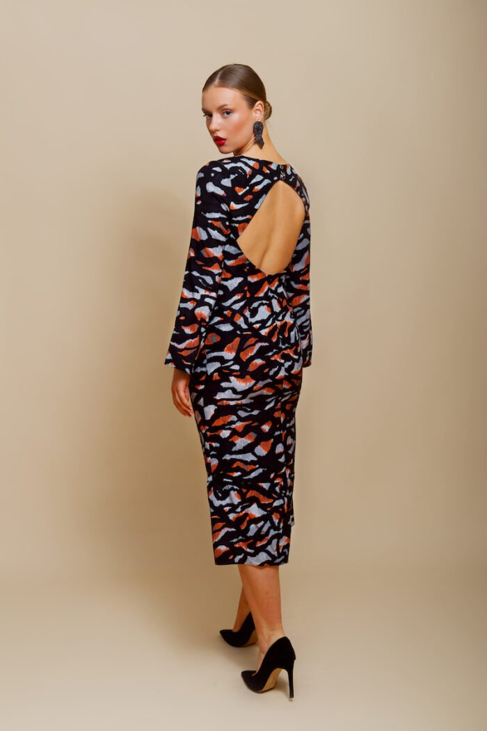 The girl wears a midi EVA dress made of black patterned silk in animal print.