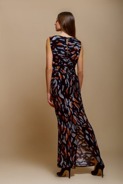 A girl wears a long silk MIRNA tiger print dress in front of a beige background.