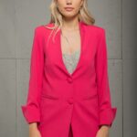 Plava devojka nosi ciklama LIVIA blejzer blago oversize kroja i stoji ispred sive pozadine.