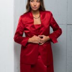 The brunette wears a LIVIA red satin blazer.