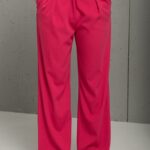 Pink SONJA pantalone na devojci koja drži ruke u džepovima.