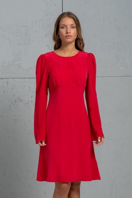 The girl is wearing a short red TEONA silk dress with long sleeves.