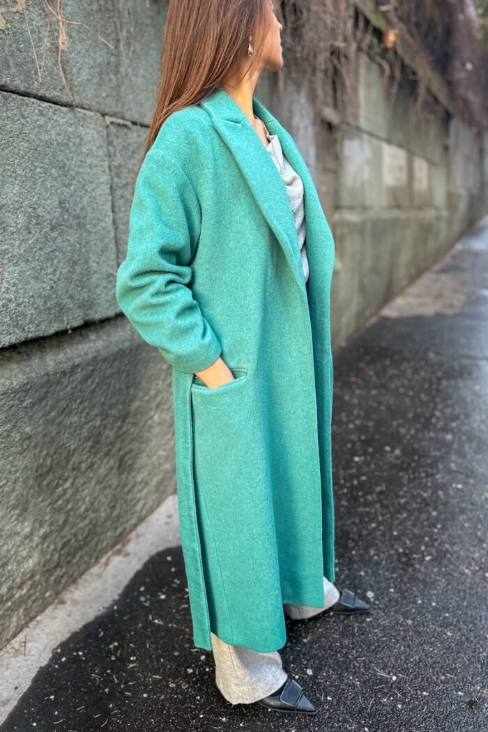 Girl wears tie-waist coat made of soft wool blend in an authentic shade of green.