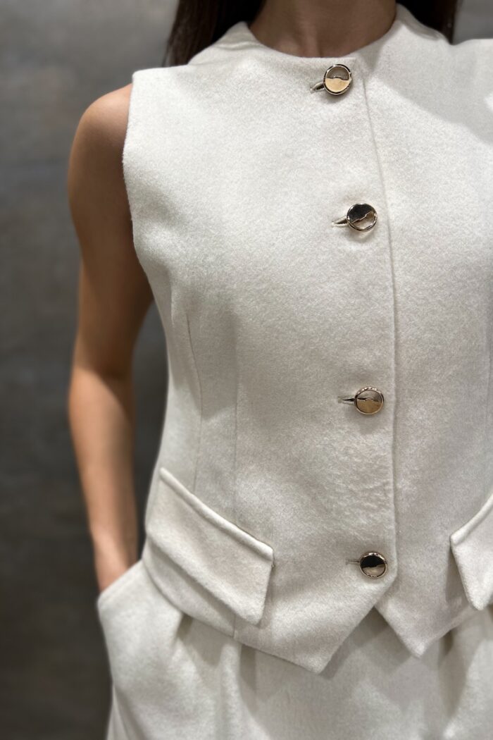 White LOU vest made of wool with golden buttons.