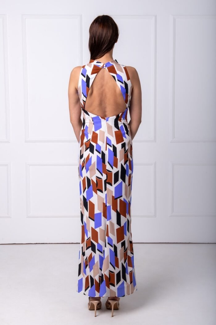 The woman wears a long sleeveless dress made of geometric print silk.