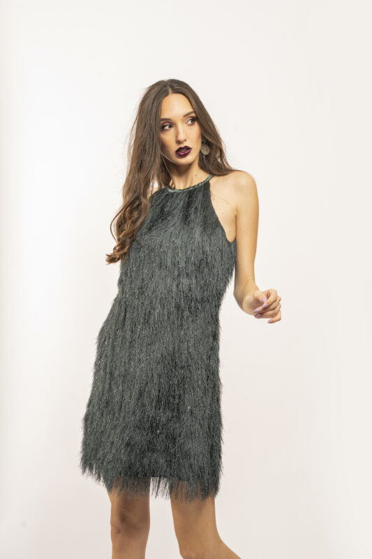 Devojka nosi kratku zelenu haljinu sa resama.