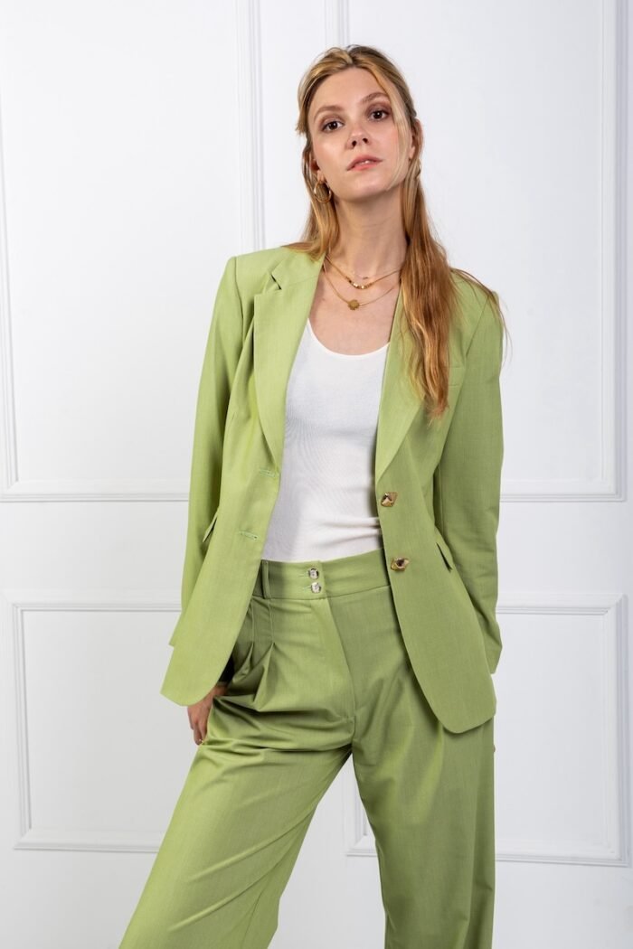 The girl is wearing a green waisted LETITIA blazer and green SONJA wide leg pants.