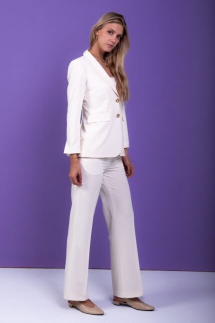 The girl is wearing a white blazer and pants set.