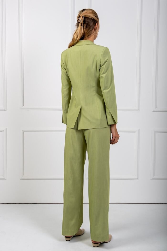 The girl is wearing a green waisted LETITIA blazer and green SONJA wide leg pants.