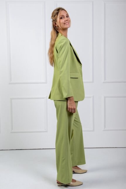 The girl is wearing a green waisted LETITIA blazer and green SONJA wide leg pants.