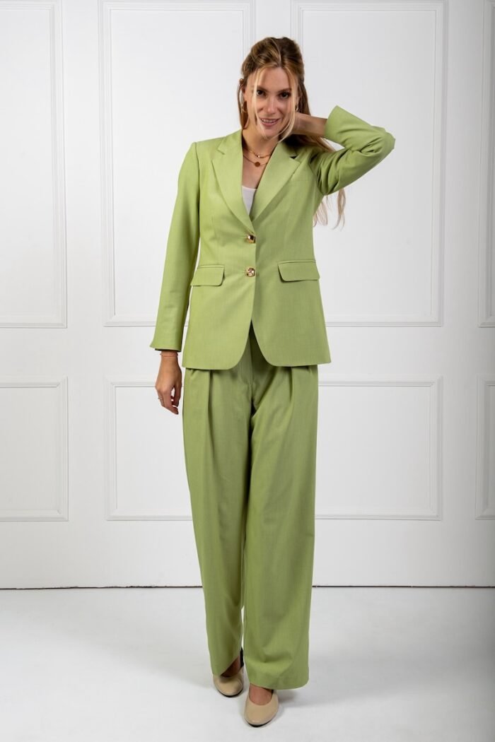 The girl is wearing a green waisted LETITIA blazer and green SONJA wide leg pants.