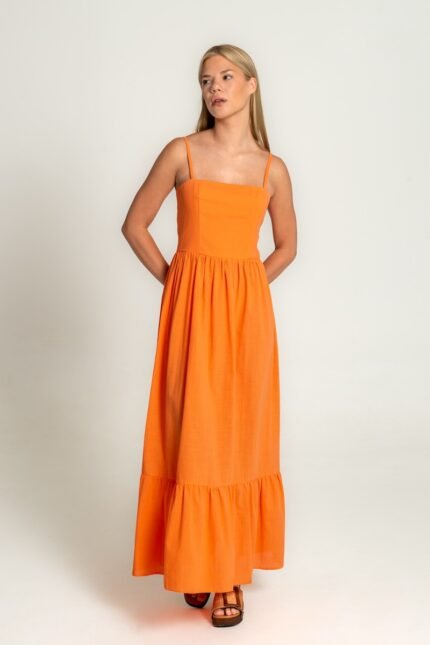 The girl is wearing a midi orange dress with straps.