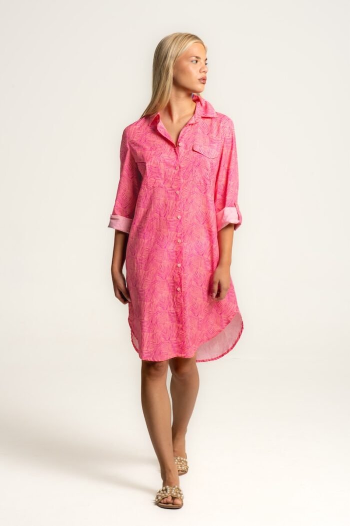 The girl wears a midi shirt-dress in a pink pattern.