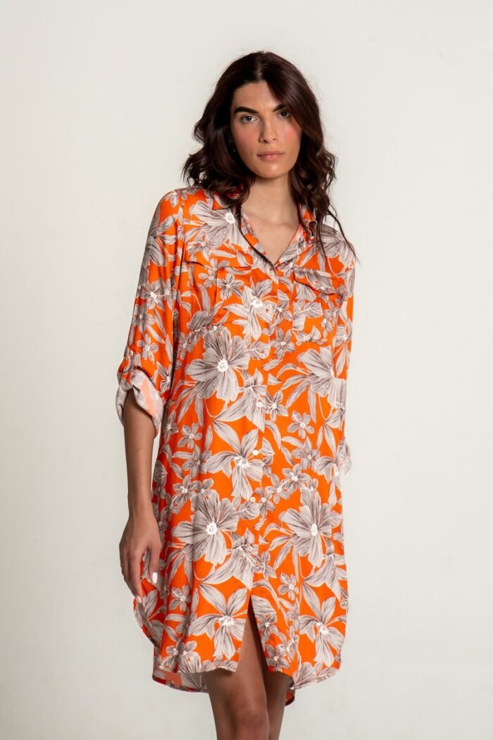 The girl wears an orange midi shirt-dress with a floral pattern.