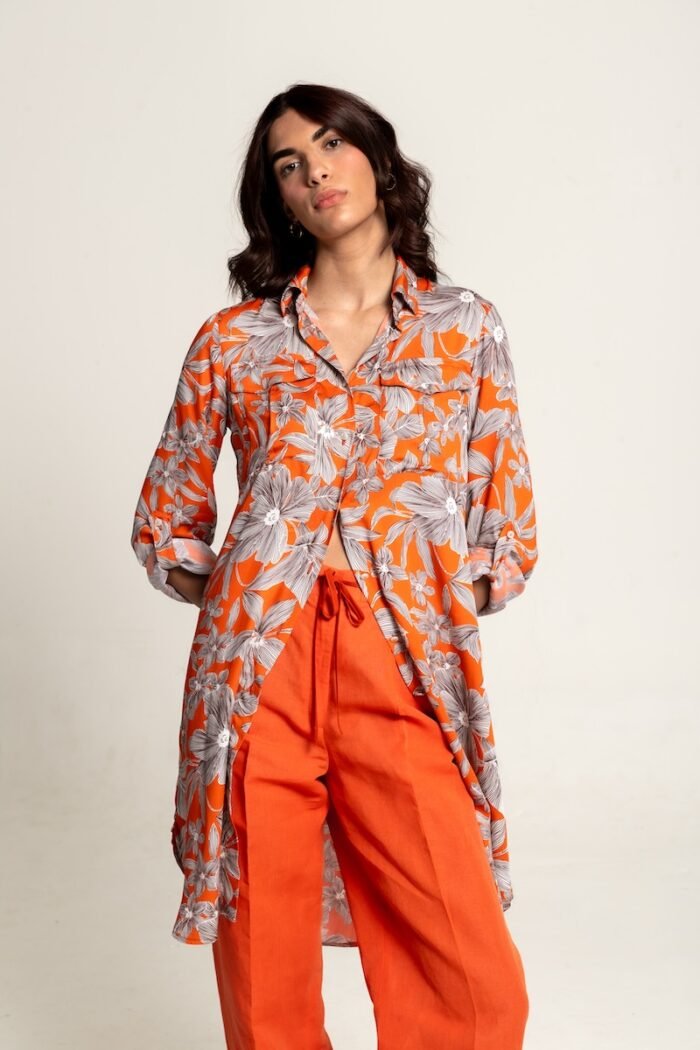 The girl wears an orange midi shirt-dress with a floral pattern.