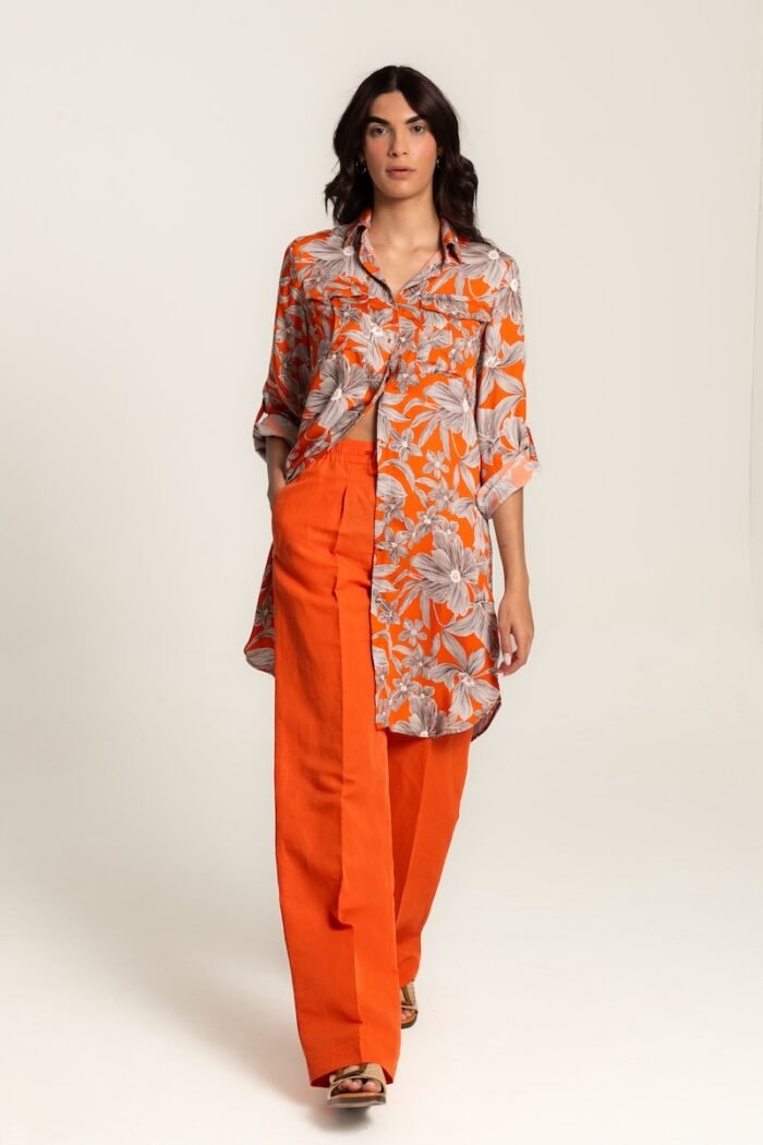 The girl wears an orange midi shirt-dress with a floral pattern.