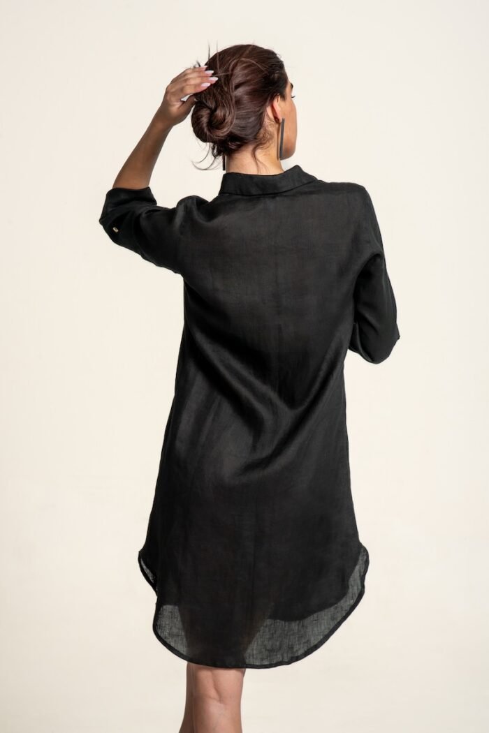 The girl wears a black linen shirt-dress.