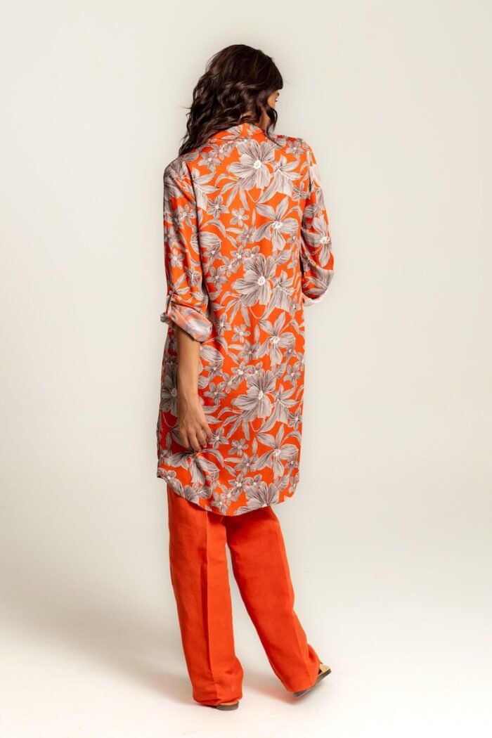 The girl wears an orange midi shirt-dress with a floral pattern.