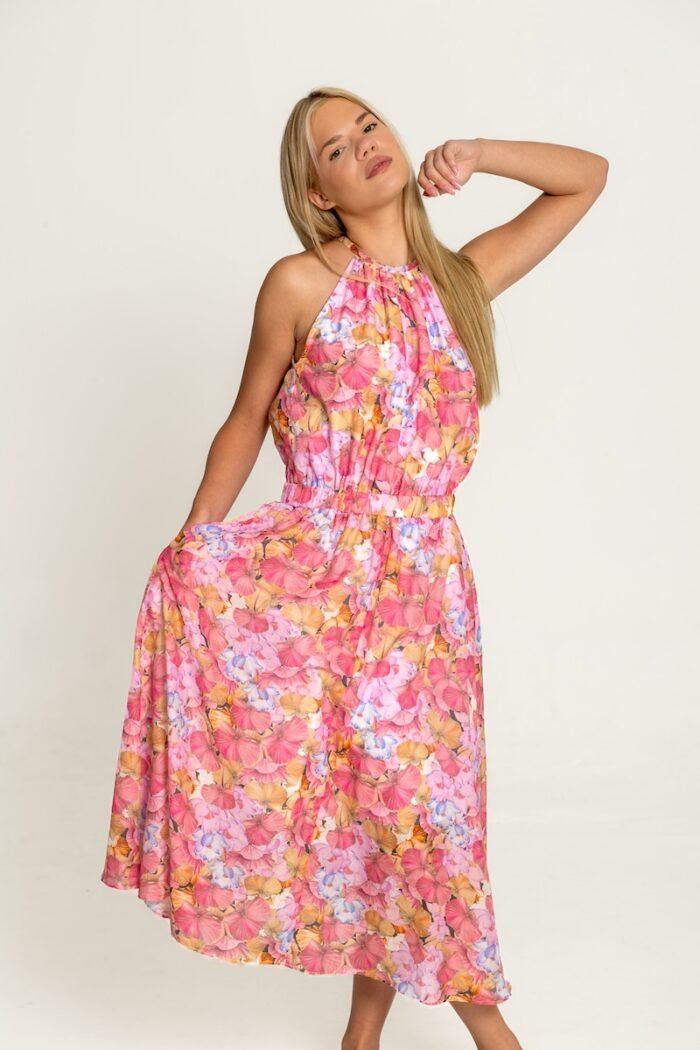 The girl wears a floral sleeveless dress.