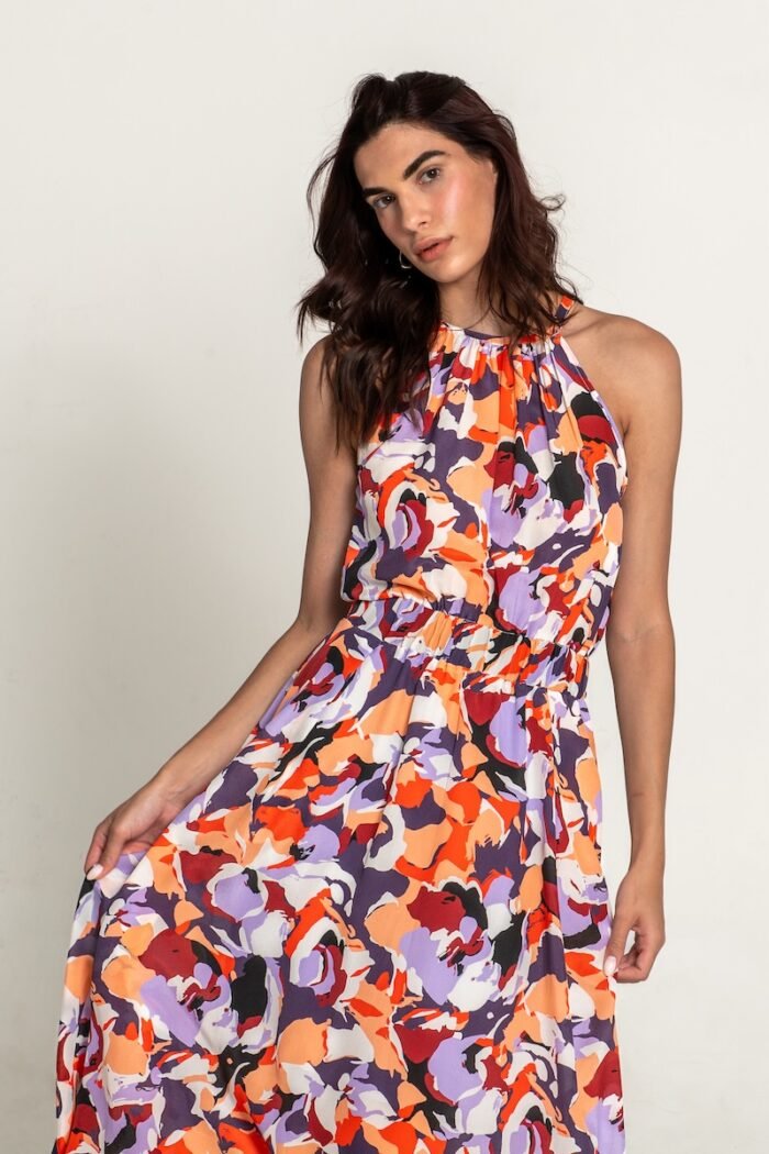 The girl is wearing a colorful patterned sleeveless midi length dress.