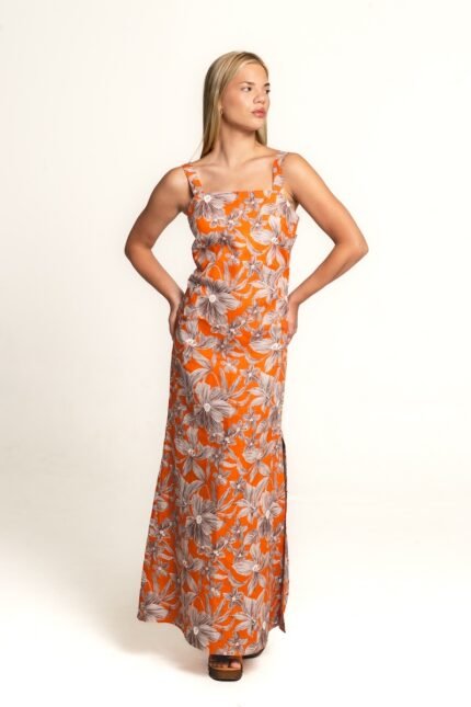 The girl wears a long, orange floral dress with wide straps.