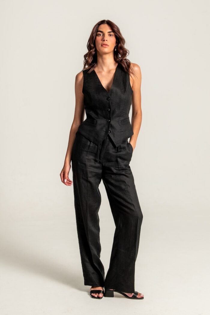 The girl wears a black linen vest and black pants.