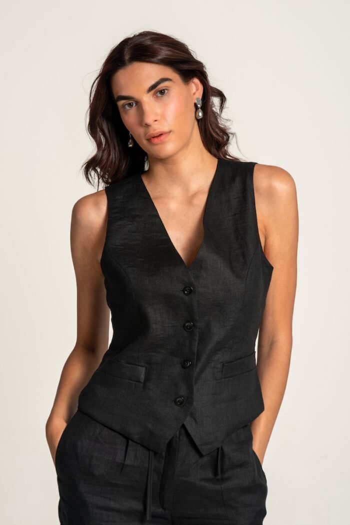 The girl wears a black linen vest and black pants.