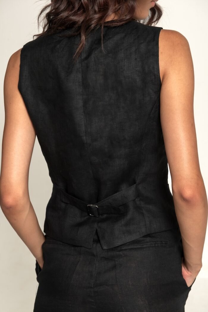 The girl wears a black linen vest.