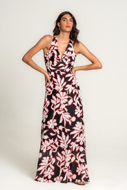 The girl wears a long, flowing black-white-red floral print dress with a cutout.