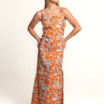 STELLA haljina dugog kroja sa tankim bretelama, u narandžastoj boji sa cvetnim dezenom, savršena za elegantne letnje kombinacije.