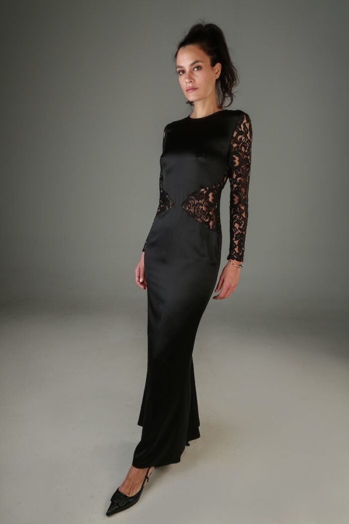 The woman wears a long dress of black satin and black lace.