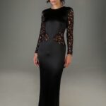 The woman wears a long dress of black satin and black lace.