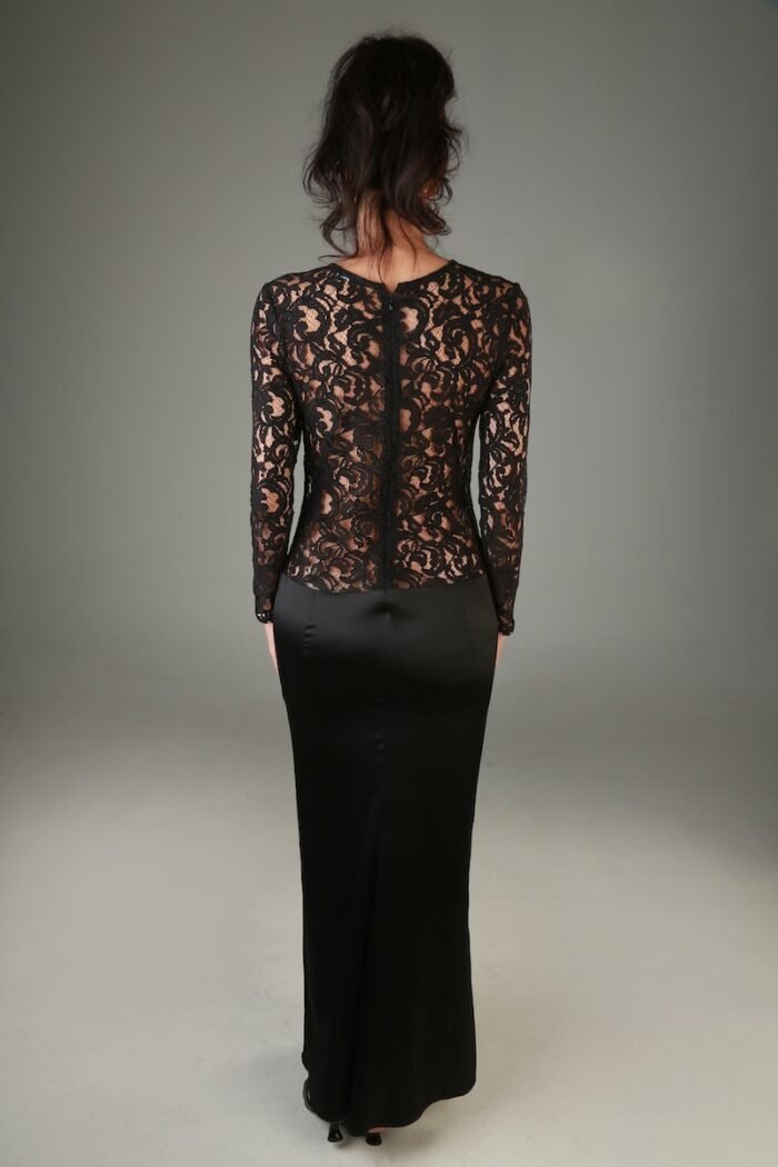 The woman wears a long dress of black satin and black lace.