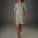 Žena nosi haljinu sa kratkim rukava kockastog dezena.