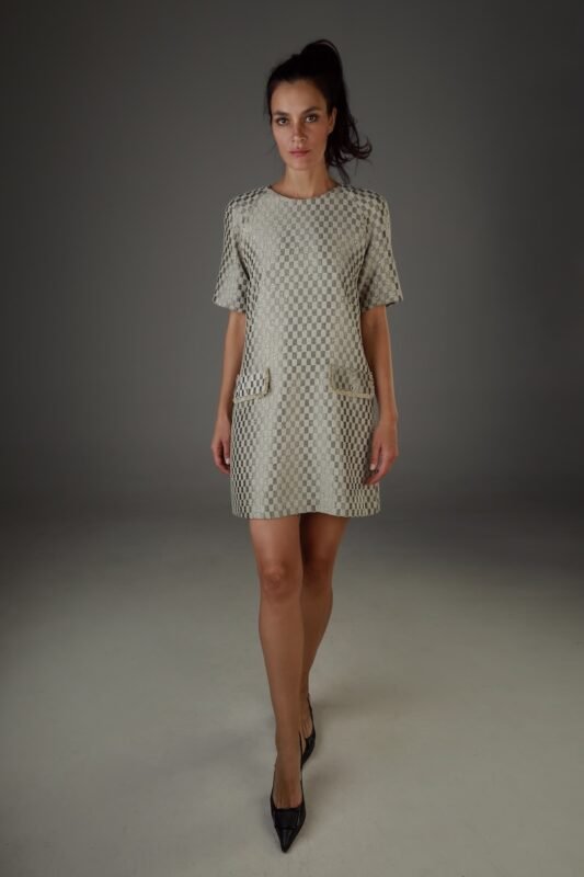 The woman wears a short-sleeved dress with a geometric pattern.