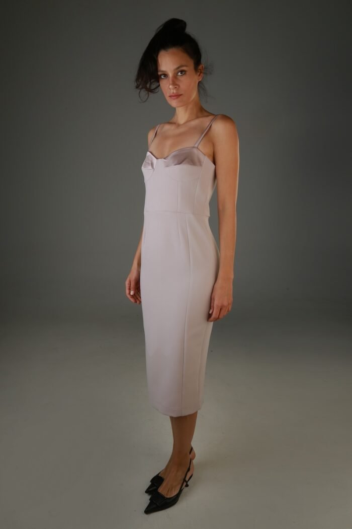 The woman wears a midi dress with straps.