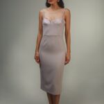 Žena nosi midi haljinu na bretele.