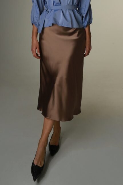 The woman wears a brown satin skirt.