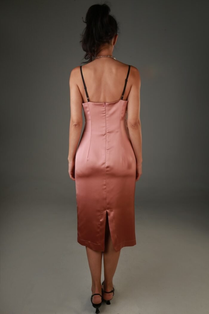 The woman wears a brown satin midi dress with black lace at the neckline.