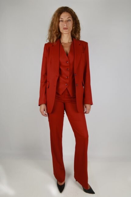 The woman is wearing a red blazer and red pants.