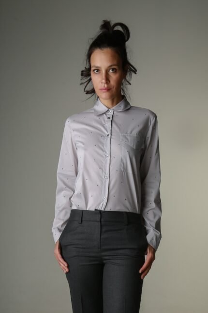 The woman wears a gray shirt with small black dots and dark gray pants.