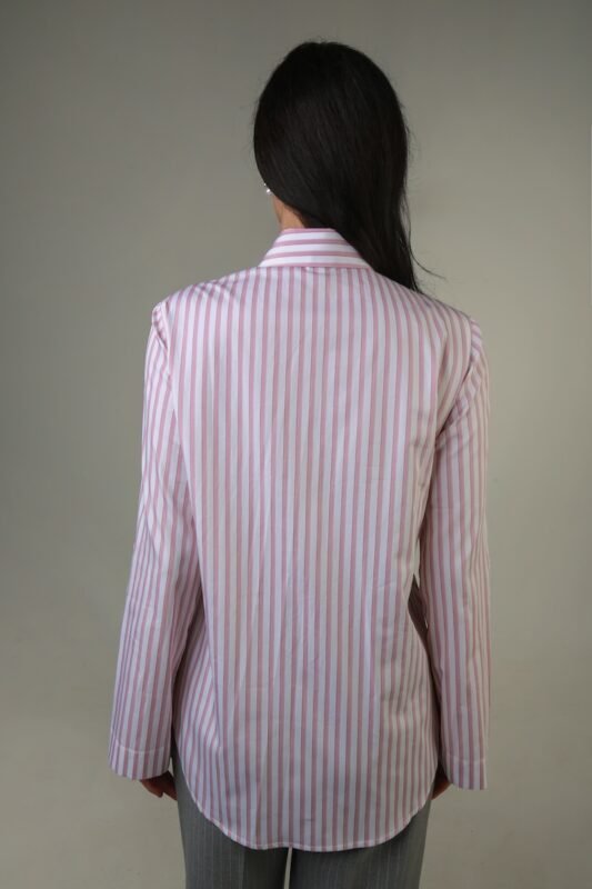 The woman wears a white shirt with pink stripes.